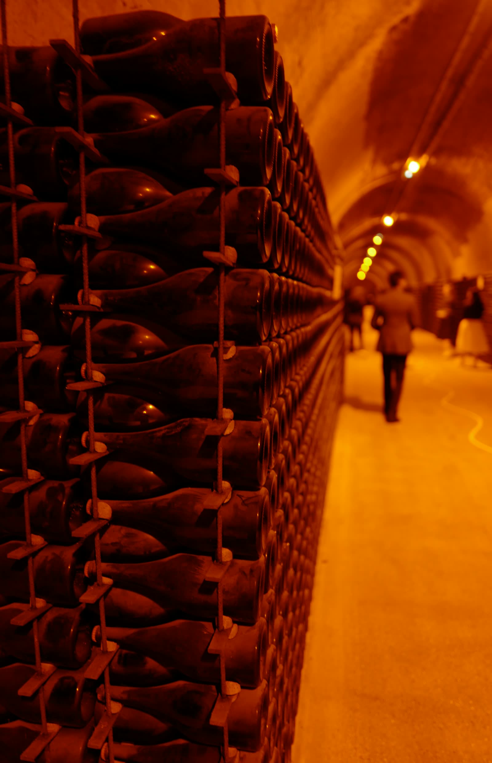 Visitors walking through a champagne cellar